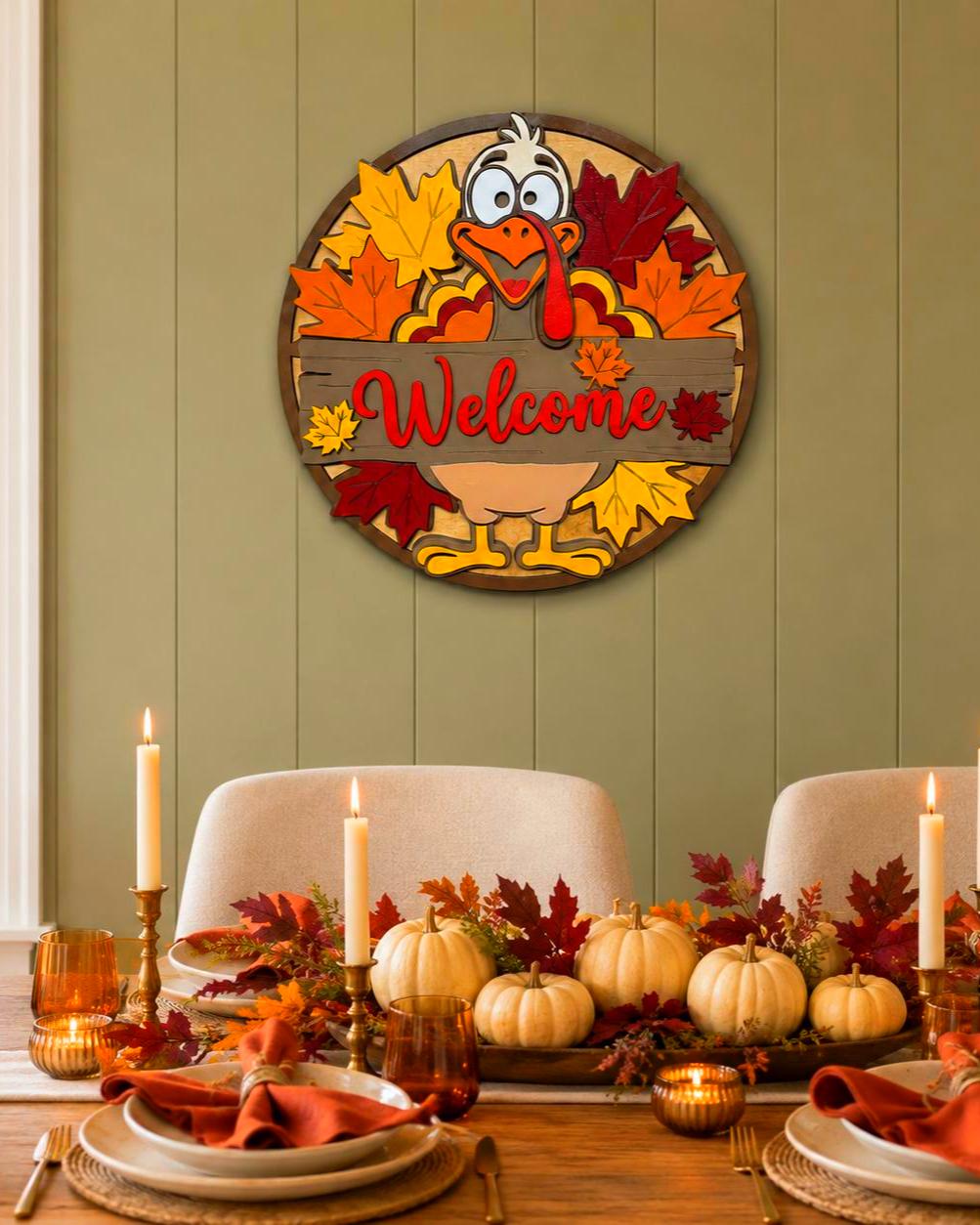 Layered wood turkey Welcome sign hanging on a sage paneled dining room wall above a Thanksgiving table with pumpkins and candles.